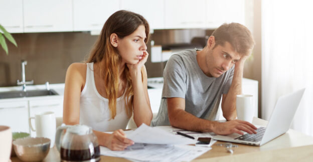 Worried couple looking at laptop together