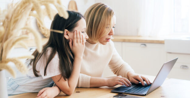 Mother and daughter sitting at table together