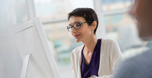 Woman looking at computer with apartment in background